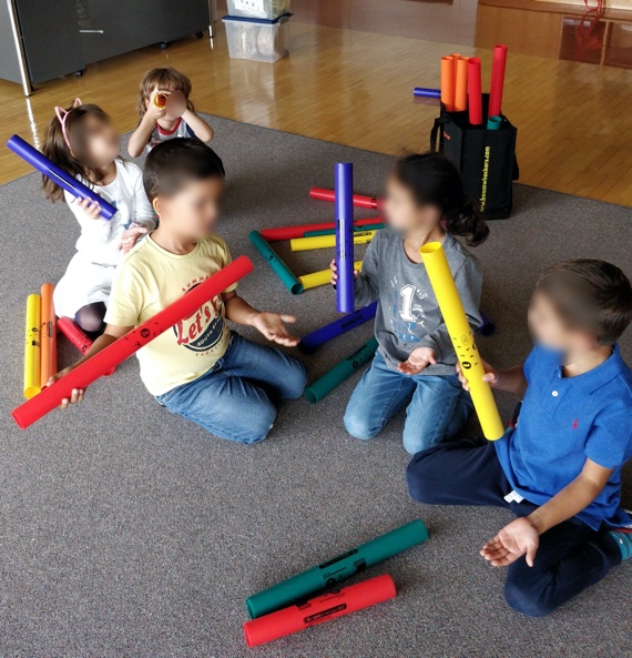 Groupe d'enfants jouant avec des tubes musicaux, appelés boomwakers