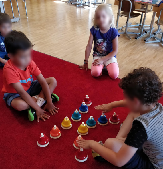 Enfants jouant avec des cloches musicales