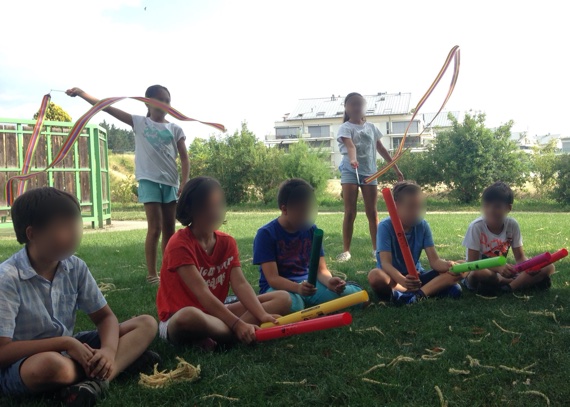 Enfants jouant avec des boomwakers à l'extérieur