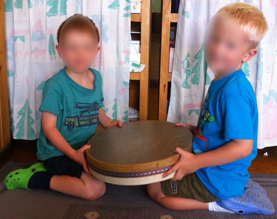 Enfants jouant avec un ocean drum (tambour à billes)